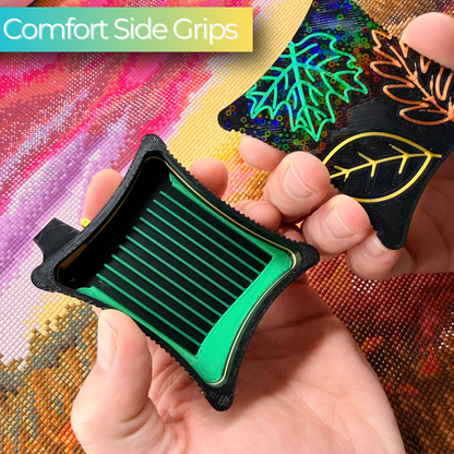 hand holding A small ergonomic magnetic diamond art tray from the Autumn Series,  embroidered leaf designs on lid magnetic base on a black tray with green lines.