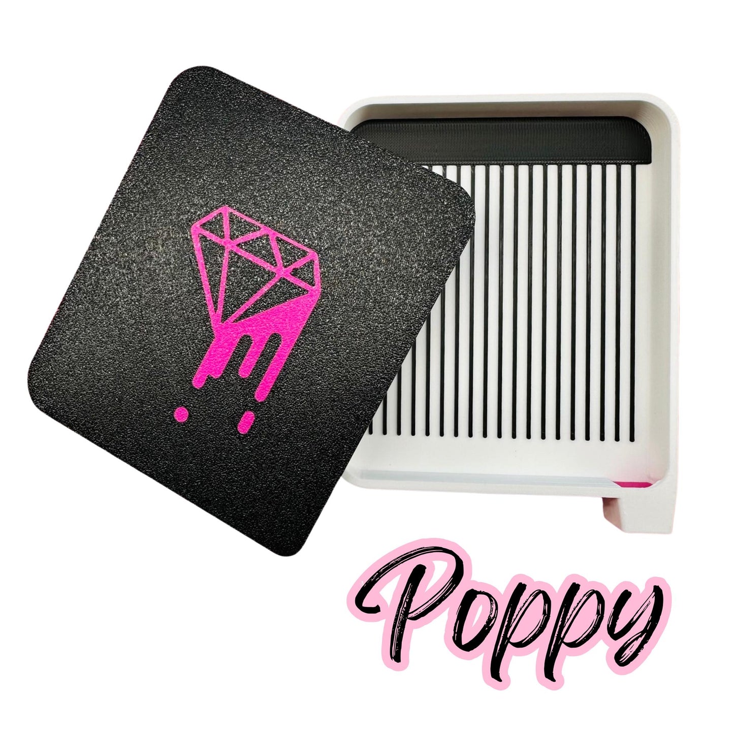 Black case with pink diamond design and white tray labeled 'Poppy' on a white background