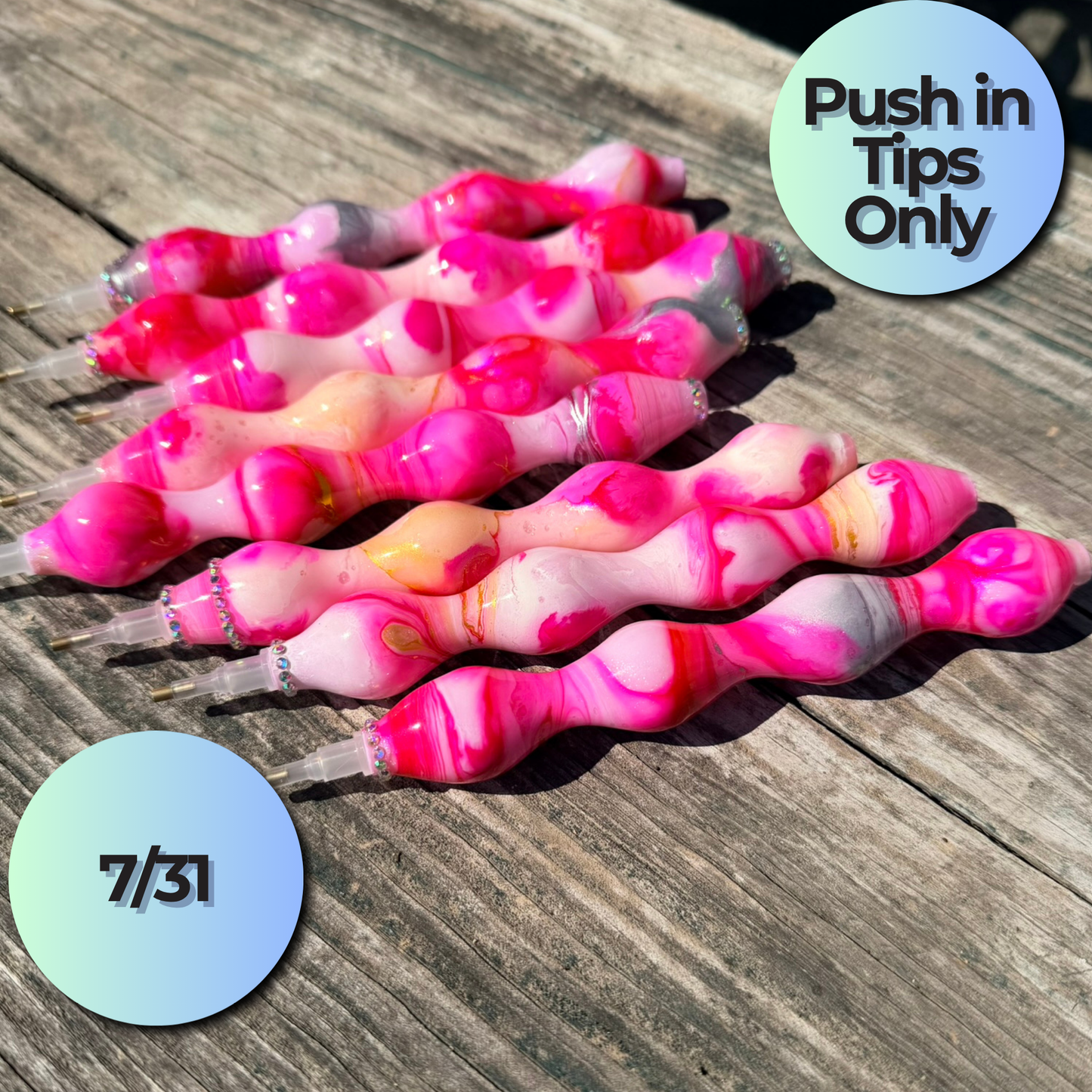 Six pink and white marbled glass bubble pen tips arranged on a weathered wooden surface, with two circular text overlays reading 'Push in Tips Only' and '7/31'.